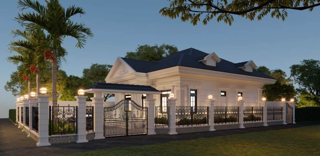 Biệt thự sang trọng với cổng sắt và hàng rào, xung quanh cây xanh và đèn chiếu sáng ban đêm.