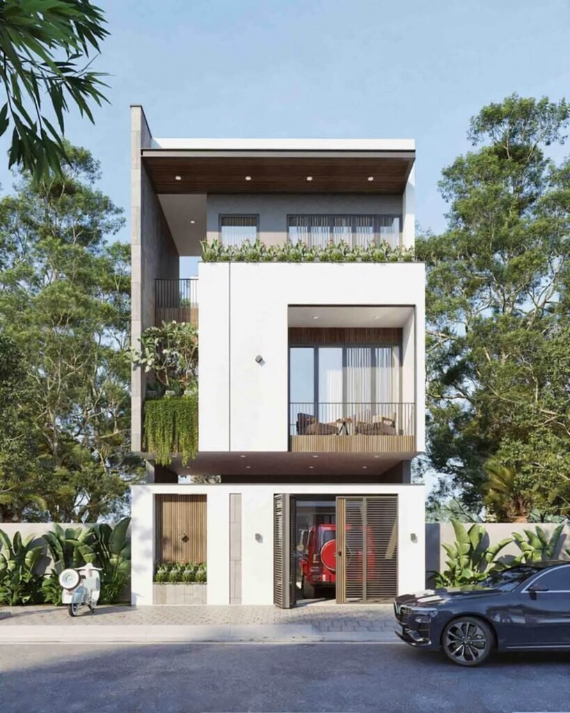Nhà phố hiện đại, ba tầng, có ban công và cây xanh xung quanh. Xe máy và ô tô đỗ phía trước.