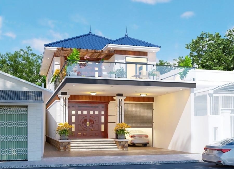 Nhà hai tầng hiện đại mái ngói xanh, ban công kính, gara và cây xanh xung quanh, bầu trời trong xanh.