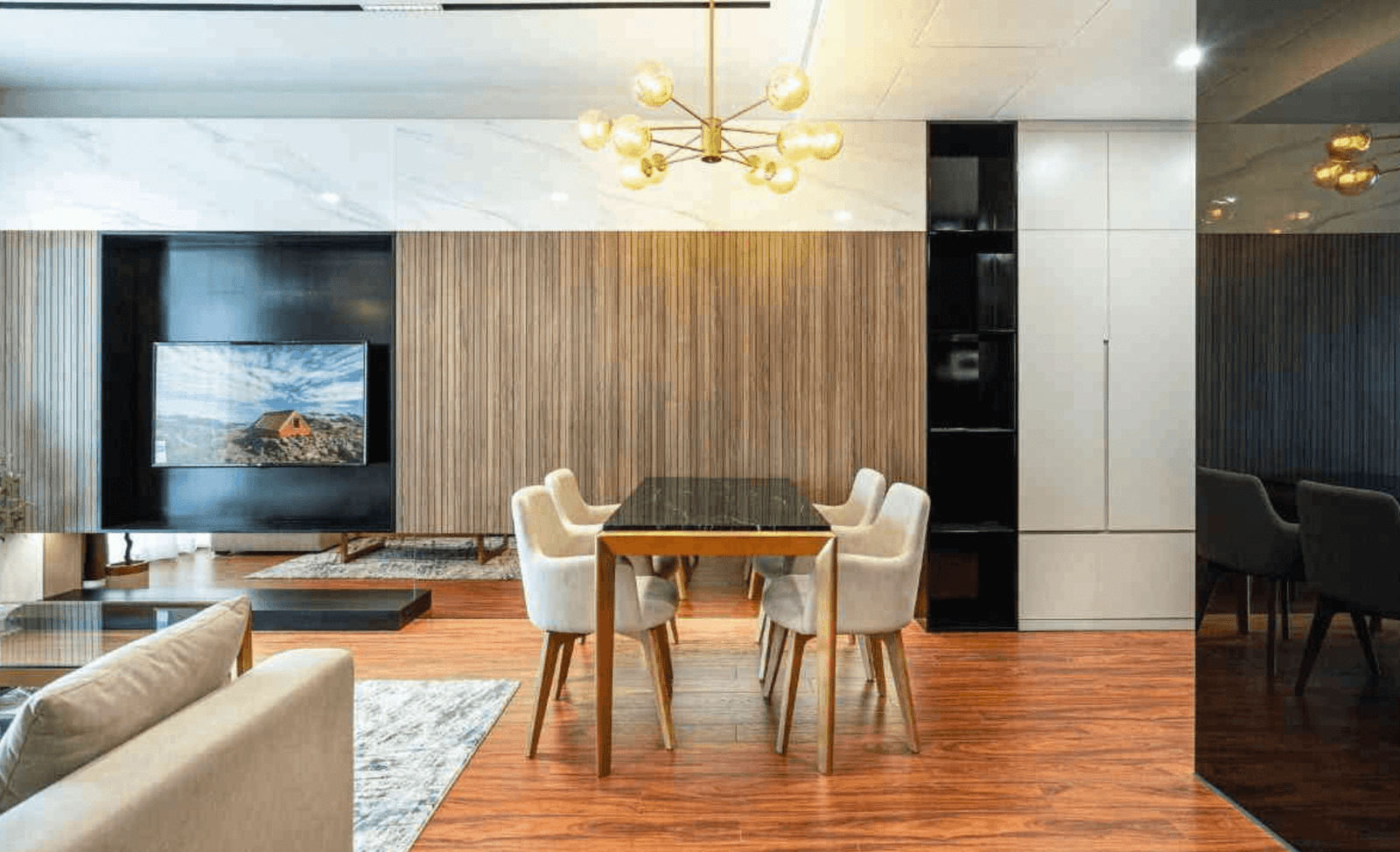 Phòng khách hiện đại với bàn ăn sang trọng, ghế bọc nệm và đèn chùm tinh tế.