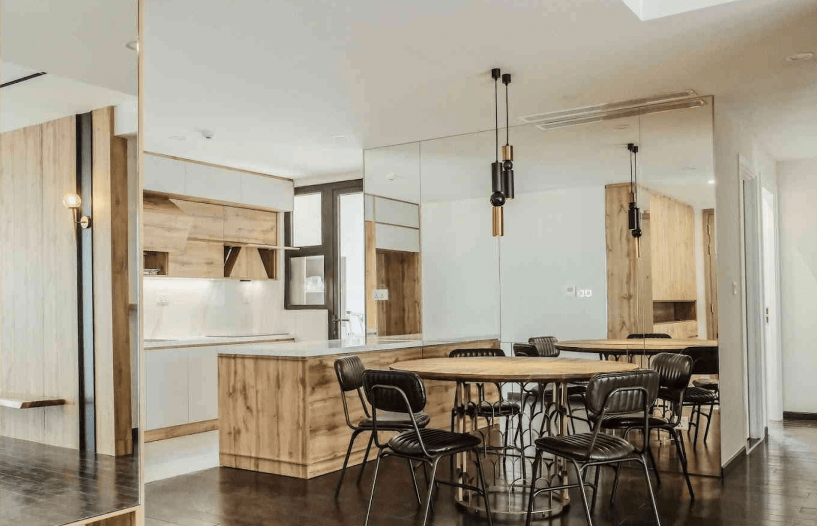 Phòng bếp hiện đại với nội thất gỗ, bàn ghế phong cách công nghiệp, đèn trần trang trí.